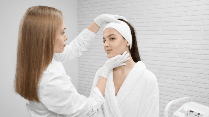 Healthcare professional examining a patient's face to determine the best treatment.