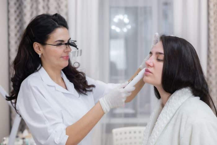 An aesthetic specialist determining if a patient can receive Dysport treatment.