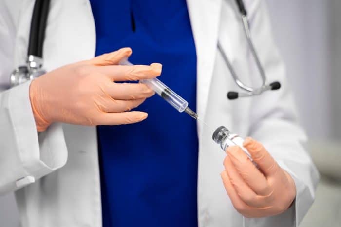 A healthcare professional carefully prepares neurotoxin injection before treatment.