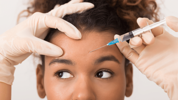 Woman getting forehead injection.