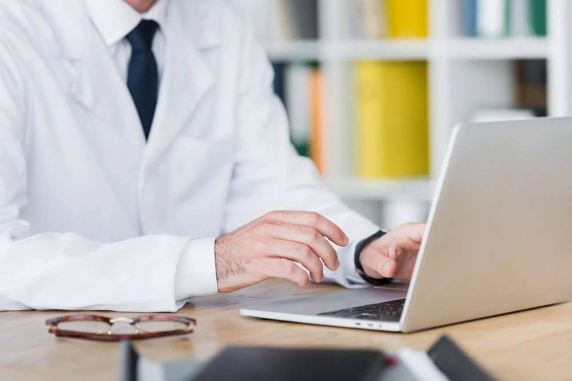 doctor checking out patient scheduling site on his laptop