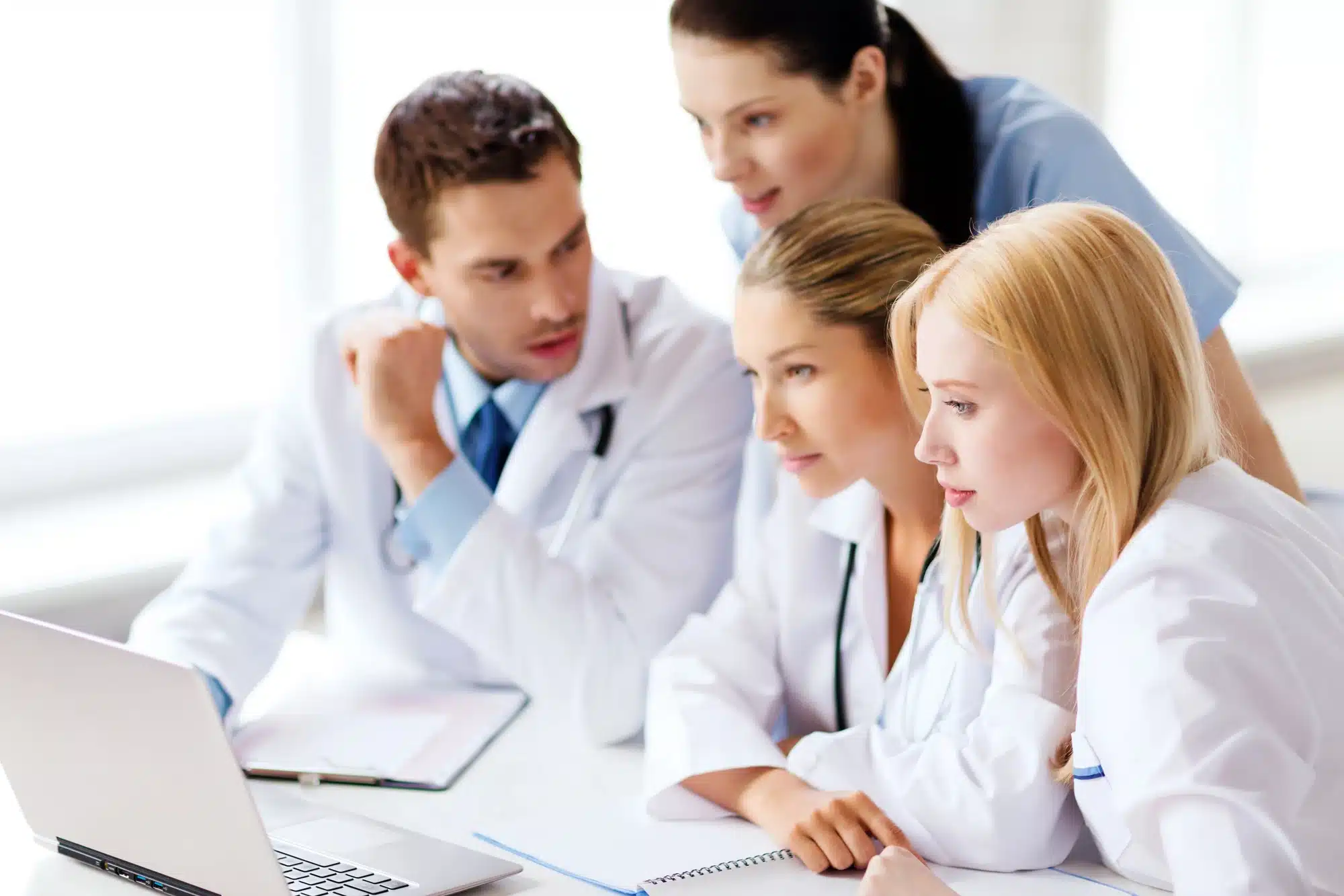 A group of medical professionals looking at the laptop screen