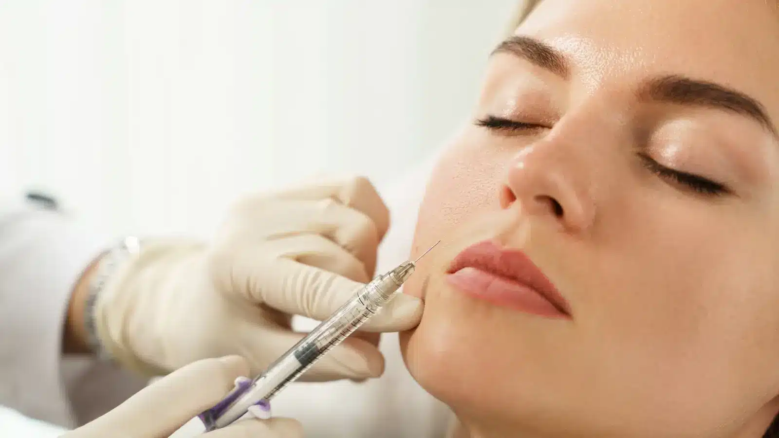 Woman getting fillers for lip enhancements.