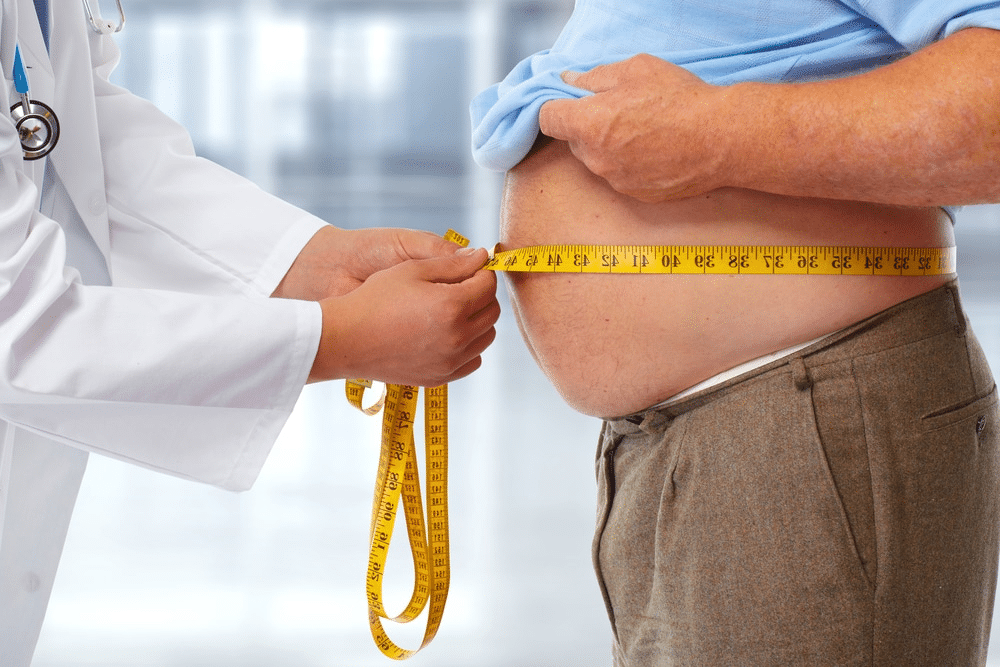 Doctor measuring waist.