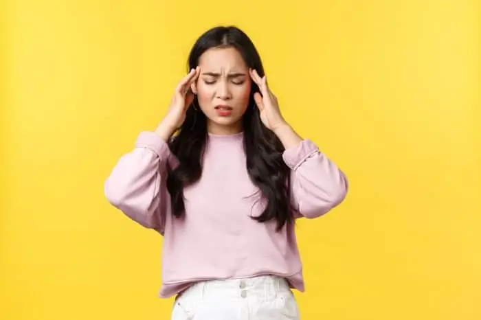 A person experiencing a headache, one of the common side effects of Evenity.