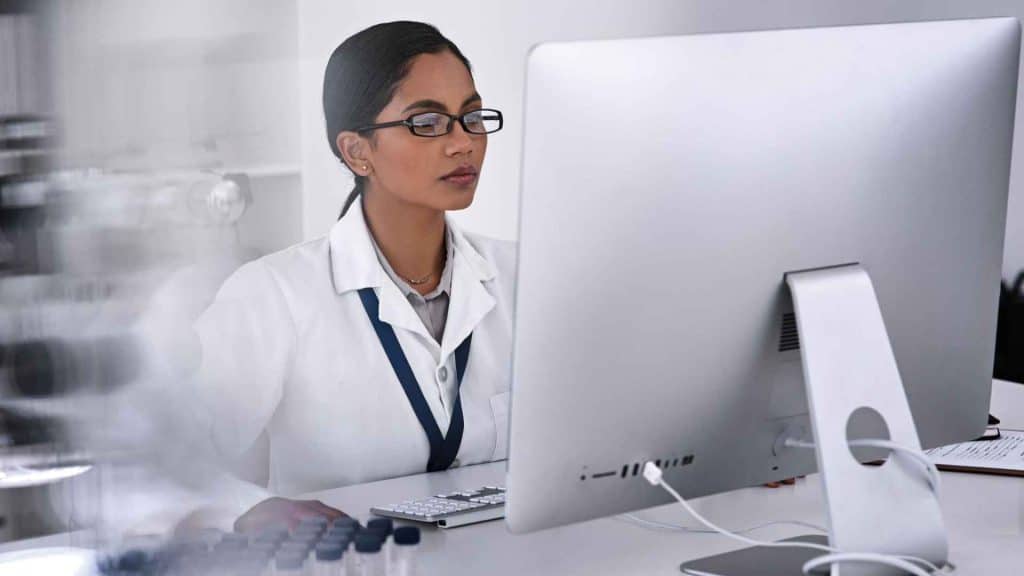 Clinician reviewing retatrutide clinical trial safety data on a laptop in a medical office