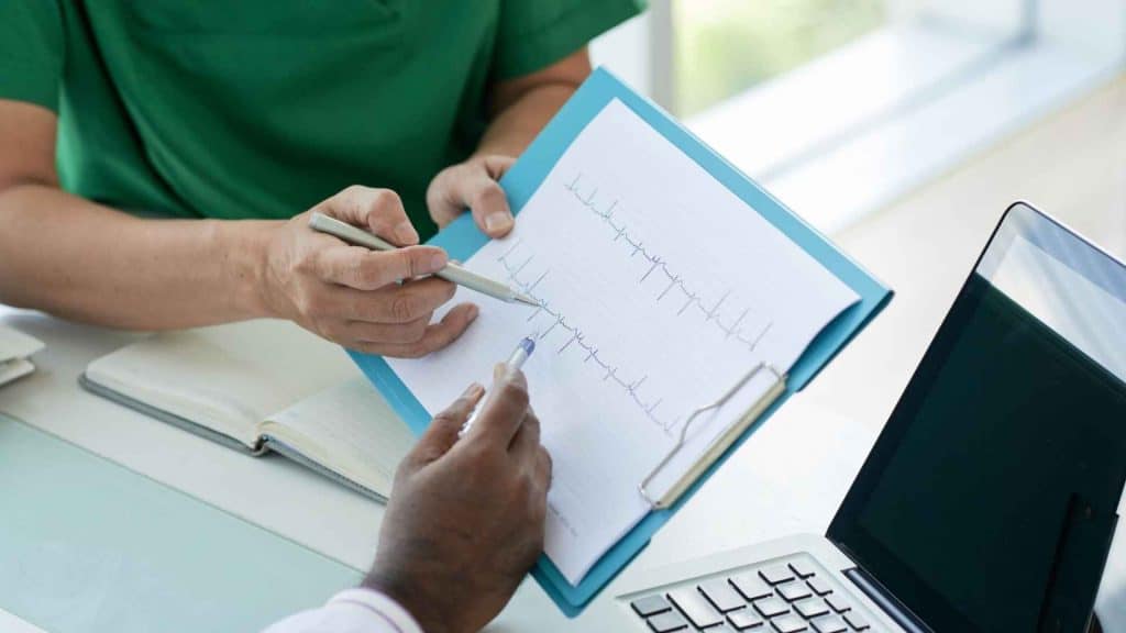 Healthcare professional monitoring an adult patient’s blood pressure during a metabolic treatment study