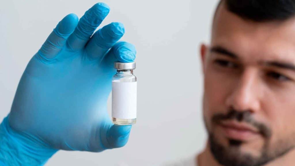 Pharmacist inspecting an unbranded injectable vial for quality and regulatory compliance