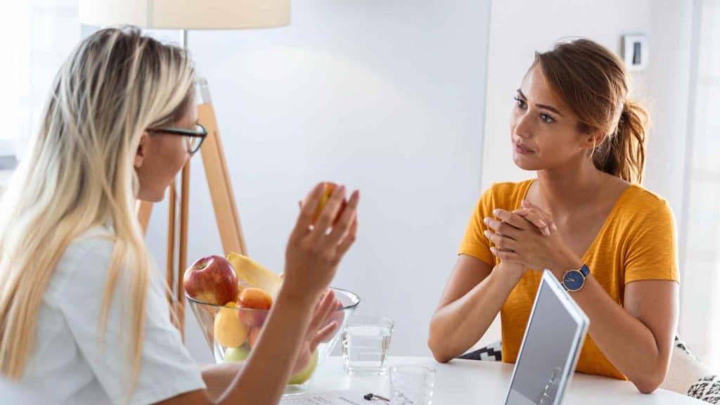 Dietitian discussing a protein-rich meal plan with an adult patient experiencing weight-related hair shedding